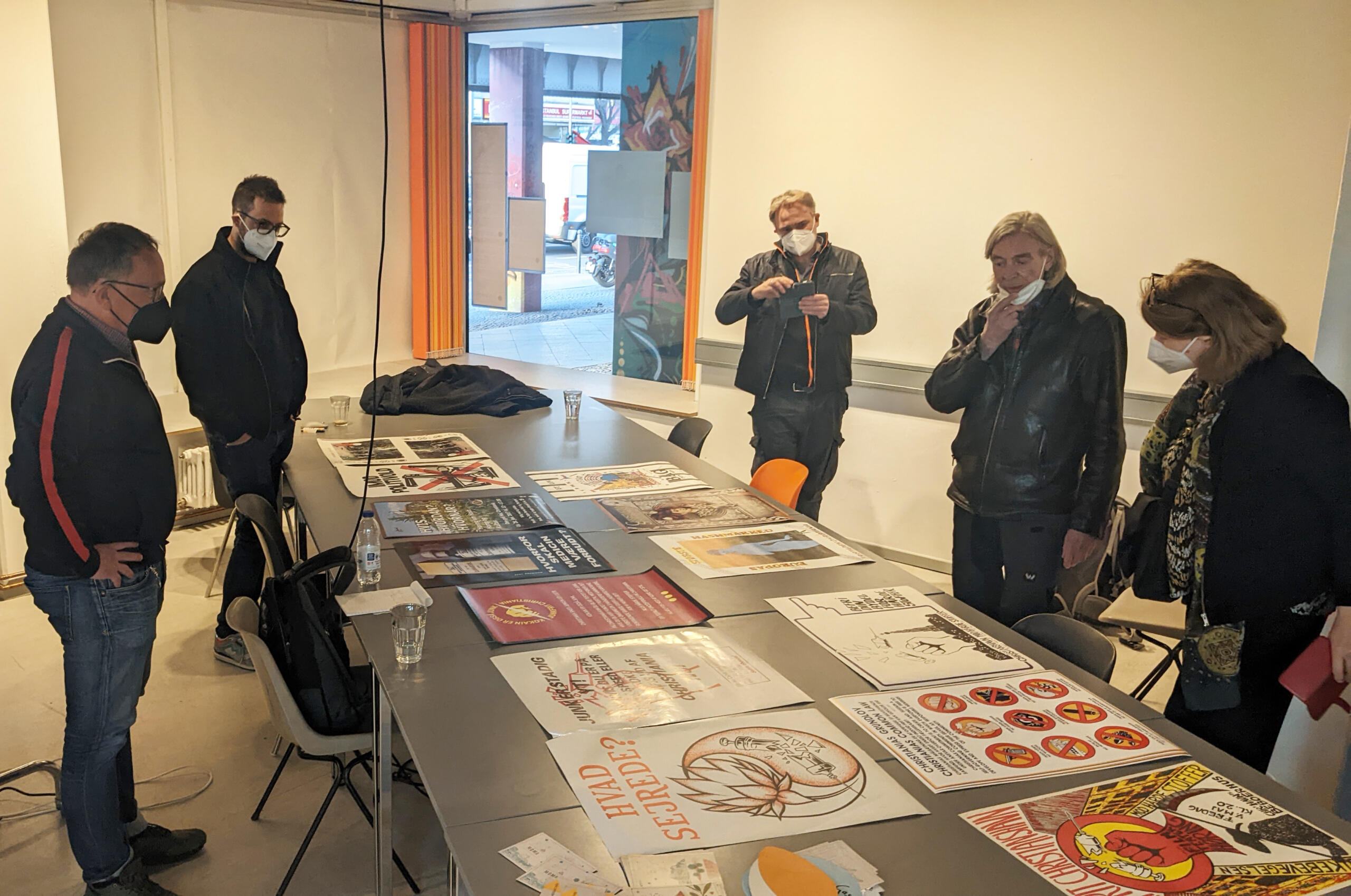 Members of the team examining posters on a table which were donated to the project